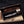 copper Damascus Bowie knife displayed with leather sheath in a wooden box