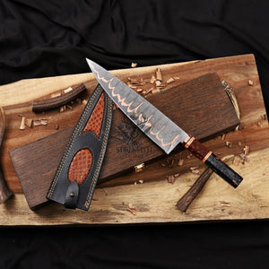 Copper Damascus chef Knife with leather sheath on a wooden box