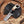 Knife with decorative handle on a black leather sheath on a wooden surface