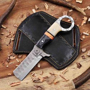 Knife with decorative handle on a black leather sheath on a wooden surface