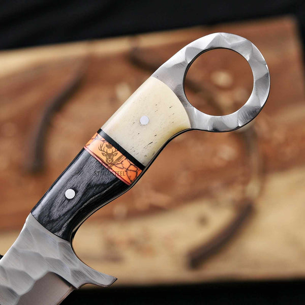 Close-up of a knife handle with wooden and metal design on a blurred background