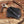Black leather case with a hunting knife on a wooden surface with wood shavings.
