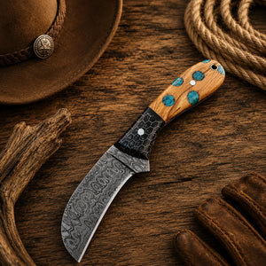 Curved Damascus skinning knife with natural turquoise inlay handle on weathered barnwood