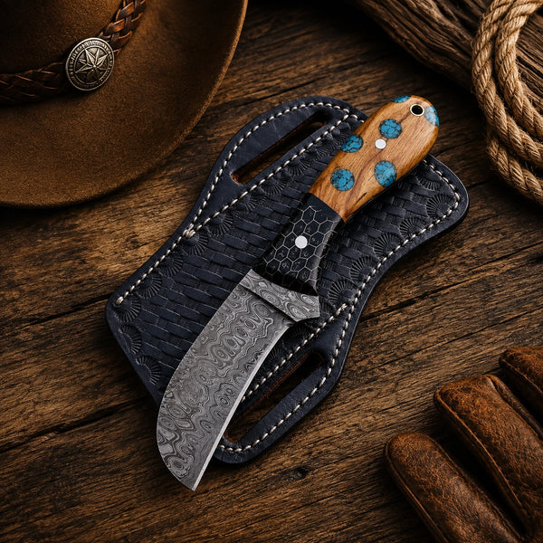 Curved Damascus skinner seated in a black basketweave tooled pancake sheath