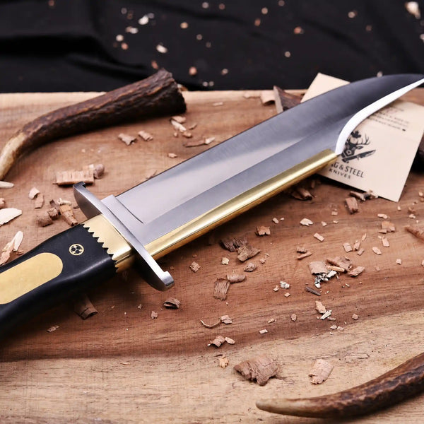 Polished D2 clip point blade with brass spine strip macro on Jim Bowie Edition knife