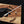 Hand holding a knife with 'Stag & Steel Knives' branding on a wooden surface.