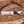 Knife with wooden handle and deer head design on a wooden surface with antlers and wood shavings.