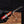 Hand holding a knife with a red handle against a blurred background