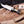 D2 Iron Mistress bowie knife with brass fittings and black G10 handle angled on wooden board