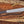 Full view of D2 machete knife with Grey Micarta handle, satin blade, and paracord on wood background