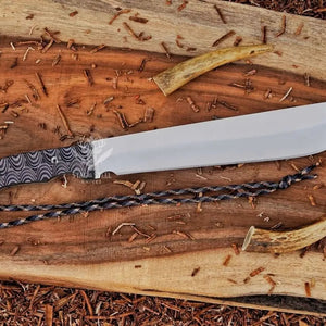 Full view of D2 machete knife with Grey Micarta handle, satin blade, and paracord on wood background