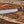 Full view of handmade D2 machete knife with Ironwood handle, blade tip pointing left, and paracord laid on wooden background