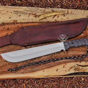 D2 steel machete knife with Grey Micarta handle, brown leather sheath, satin blade, and paracord on wood background