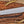 Close-up of satin D2 steel machete blade showing cutting edge, blade profile, and handmade finish