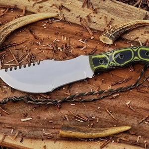 D2 steel tracker knife with Micarta handle, blade tip pointing left, notched spine, and paracord on wood background