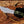 D2 tracker knife with green Micarta handle shown in hand for grip, blade shape, and size reference