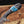 Knife with a decorative handle featuring blue and gold inlay on a blurred natural background