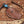 Brown leather knife sheath with 'Stag & Steel Knives' logo on a wooden background with wood shavings.