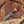 Knife with wooden handle and leather sheath on a wooden surface