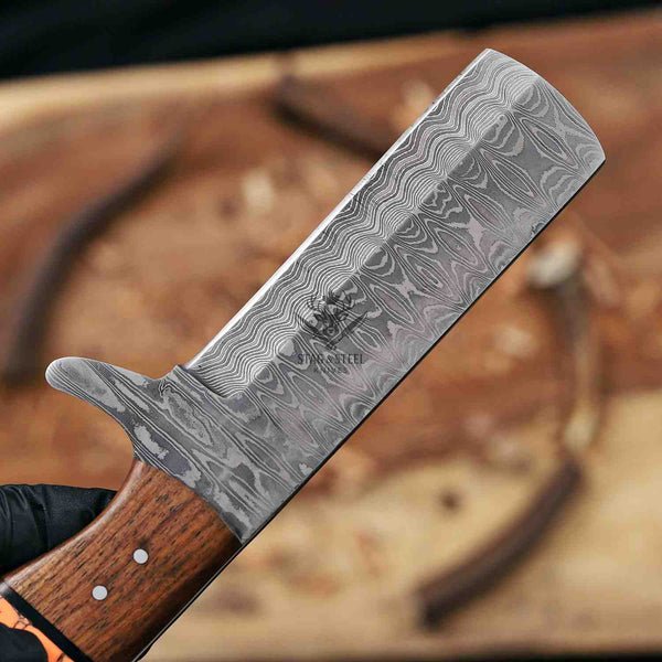 Damascus knife with wooden handle held by a gloved hand against a blurred background
