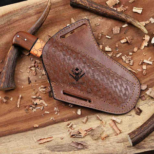 Brown leather sheath with stitching details on a wooden surface with wood shavings