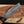Damascus steel knife blade with a wooden handle on a wooden surface