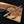 Hand holding a knife with 'Hag & Steel Knives' branding on a wooden background
