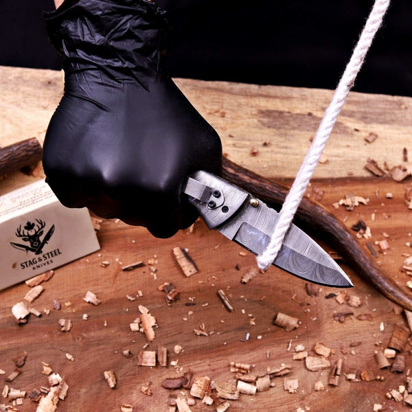 Damascus folding knife performing rope cutting task during edge sharpness demonstration