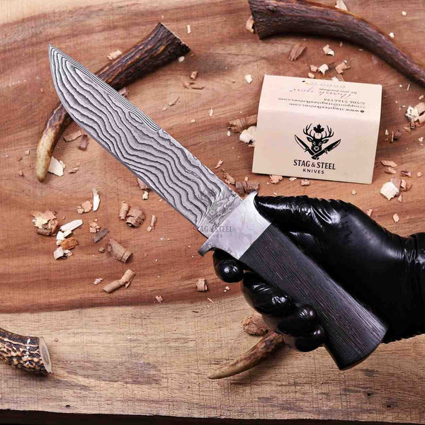Forged Damascus guard meeting wenge wood handle on hunting knife
