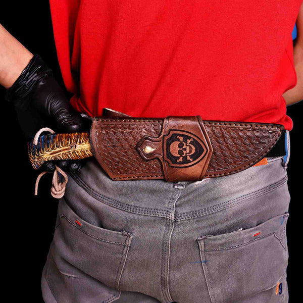 Damascus hunting knife in horizontal carry skull leather sheath on belt