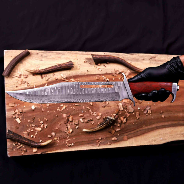 Damascus pommel of bowie knife held in gloved hand