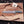 Damascus steel tactical bowie knife flat lay on wooden board with textured green handle and antler accents
