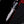 Close-up view of Damascus steel bowie knife held by gloved hand showing double finger guard and textured handle scales
