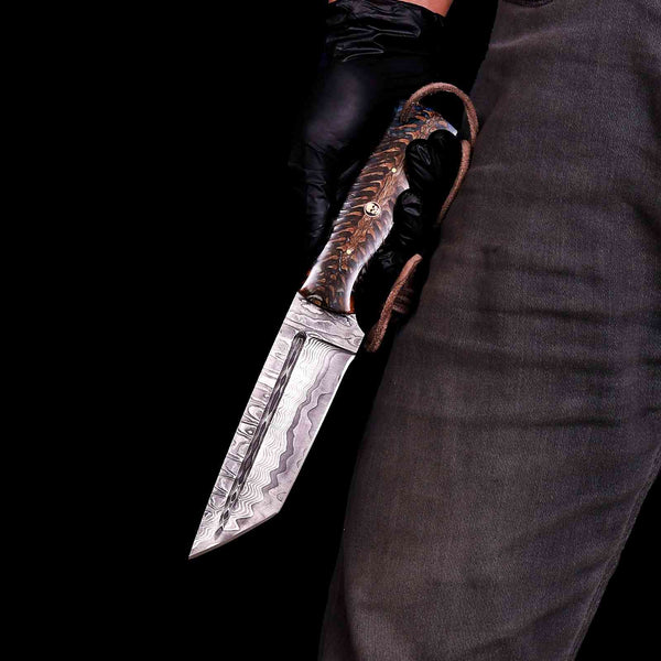 Damascus tanto knife with pine cone handle held in hand