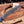 A Close up of San Mai Damascus steel blade knife with a beautiful patterned blade and a blue handle, displayed diagonally on a wooden cutting board with wood shavings and antlers.