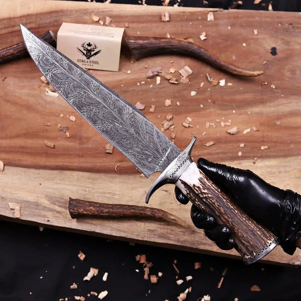 Gloved hand holding Feather Damascus bowie knife showing 10 inch feather pattern blade