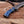 Rear view of Damascus finger guard bowie knife with blue resin handle on wooden board