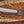 Full tang D2 steel machete knife with Grey Micarta handle, satin blade, and paracord on rustic wood