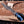 Gloved hand holding handmade Damascus finger guard bowie knife over wooden board