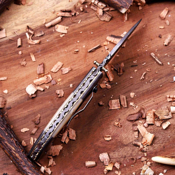 Handmade Damascus folding knife showing Brass file work spine and custom craftsmanship