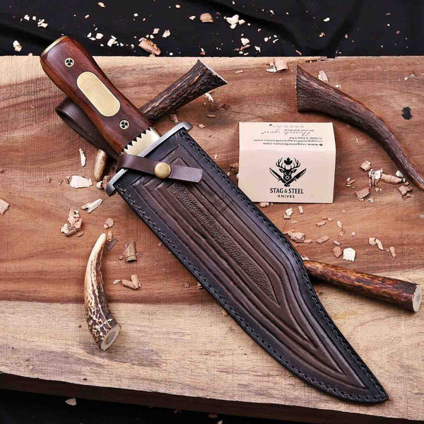 Iron Mistress bowie knife seated in tooled leather sheath with retention strap