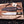 Jim Bowie Edition D2 Iron Mistress bowie knife with black G10 handle beside tooled leather sheath