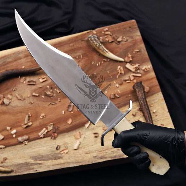 D2 Bowie knife held in a gloved hand, clip-point blade detail