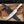 D2 Bowie knife and black leather sheath crossed on a wooden plank