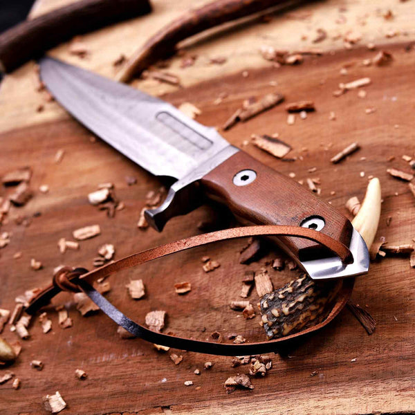 Full-tang brown micarta handle on a Damascus bowie knife with leather cord
