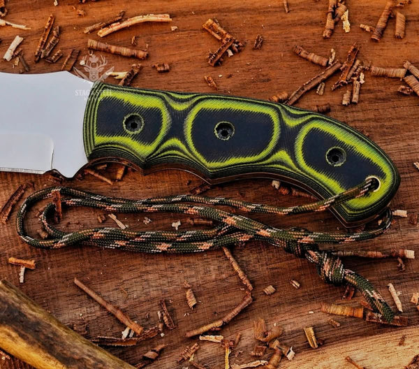 Close-up of green Micarta handle on handmade D2 tracker knife with handle pins and paracord lanyard