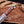 Brown micarta handle and forged Damascus guard with leather lanyard on bowie knife