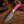 Pink turquoise cowboy knife beside black leather pancake sheath with basketweave tooling