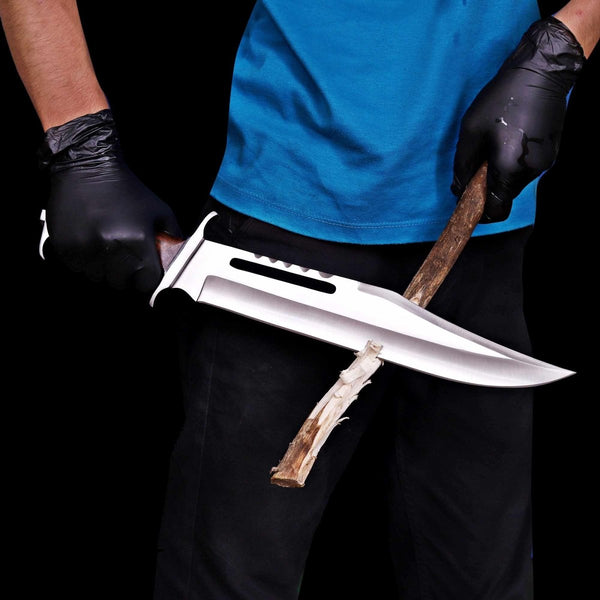 Rambo III D2 steel bowie knife held in hand showing in action cutting firewood