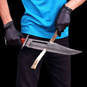 Rambo III Damascus bowie knife held in for live action showing blade cutting through wood.